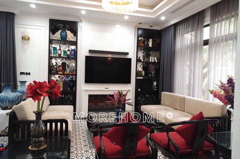 .
Phòng khách được trang bị nội thất theo phong cách truyền thống bằng bộ sofa gỗ Việt cao cấp, đệm trắng và đệm đỏ kết hợp lại tạo nên một vẻ đẹp ấm áp cho căn phòng.
